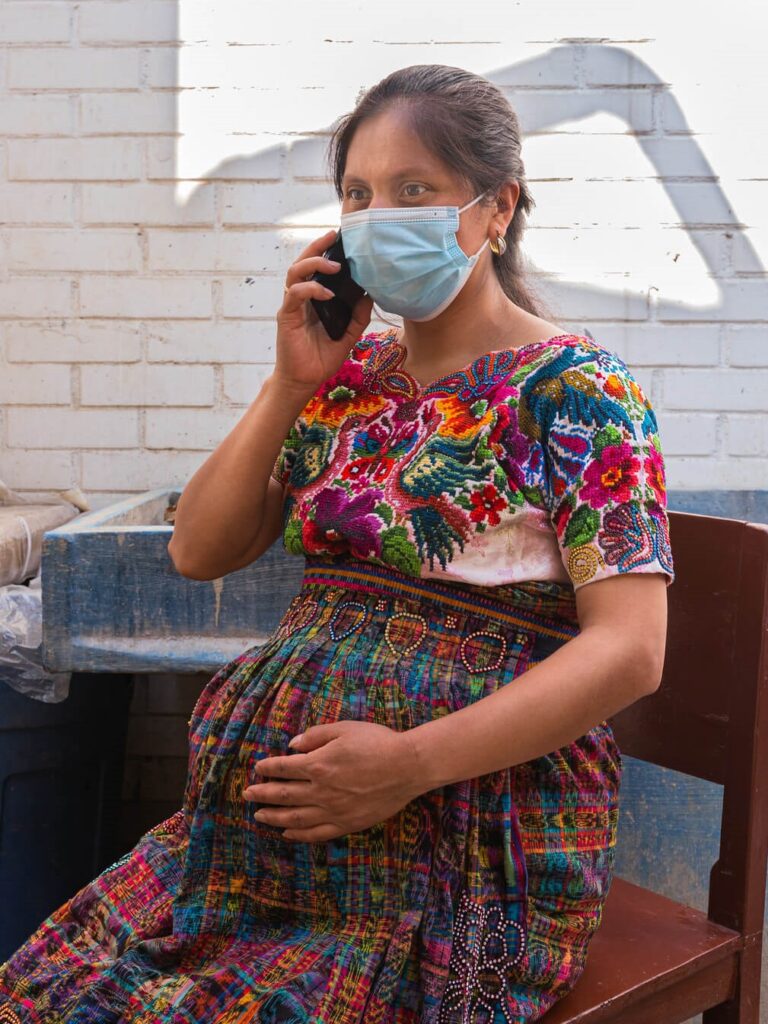 A pregnant women in Guatemala speaks on the phone with health services provider.