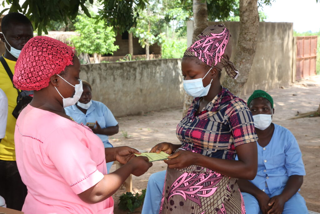 A health worker in BEnin talks with a woman about COVID
