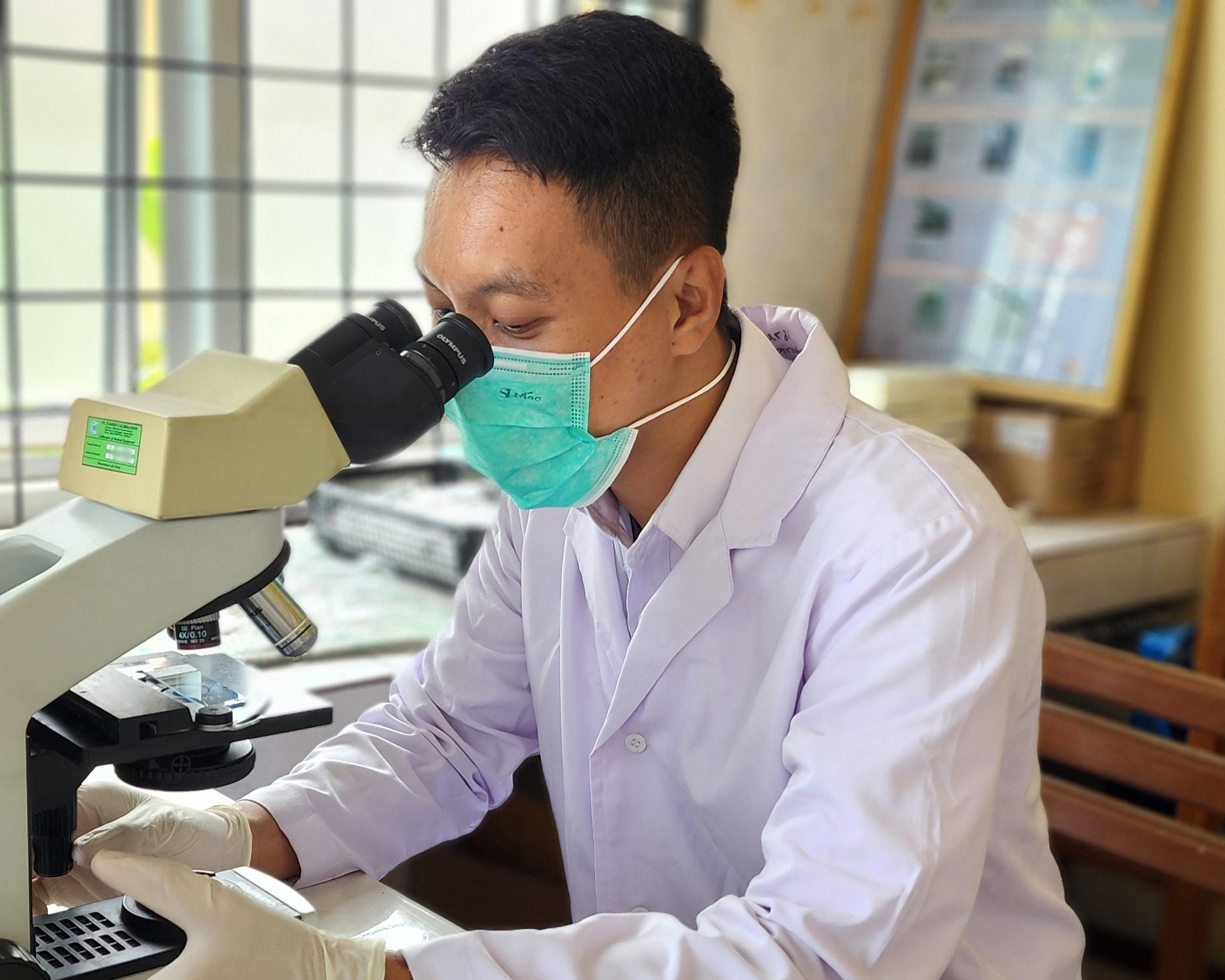 Um técnico de laboratório analisa uma amostra de TB. BEBAS-TB, Indonésia