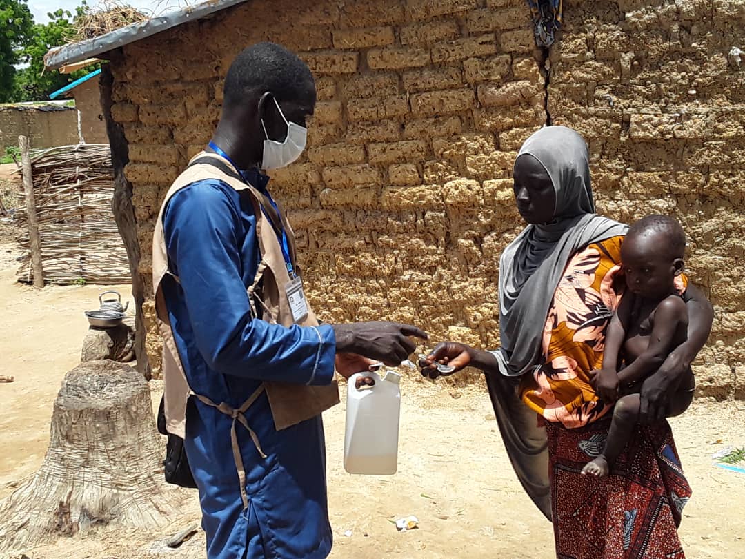 Diapositive 1-Un ASC donne une cuillère à une mère pour la première dose de traitement à Karimama (Alibori). Crédit photo - Dr Jocelyn Akakpo
