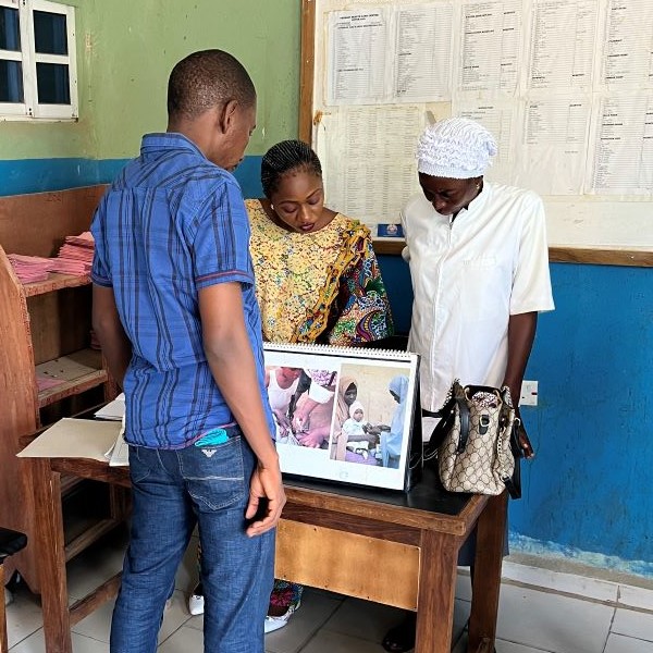 Un homme reçoit une formation sur la documentation des cas de paludisme dispensée par deux agents de santé. Projet de lutte contre le paludisme du Fonds mondial – Nigéria. Crédit photo : MSH