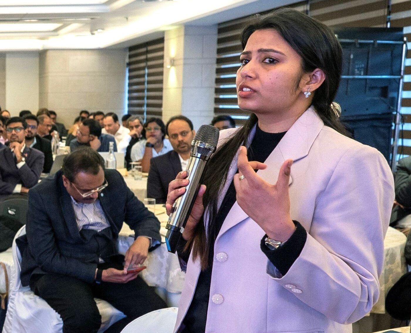 Uma mulher fala com paixão segurando um microfone para Quase 150 representantes de 25 estados indianos participaram num workshop de dois dias em Nova Deli, em Fevereiro, sobre o envolvimento do sector privado na eliminação da TB. O workshop foi liderado pela Divisão Central de TB da Índia, com o apoio do projecto de Sistemas de Saúde para TB da USAID (HS4TB) liderado pelo MSH e do Banco Mundial. Foto de HS4TB.