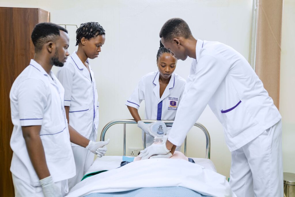 Vier Hebammenstudenten üben in einer Ausbildungseinrichtung in Ruanda Reanimationstechniken an einer Übungspuppe. Bildnachweis MSH