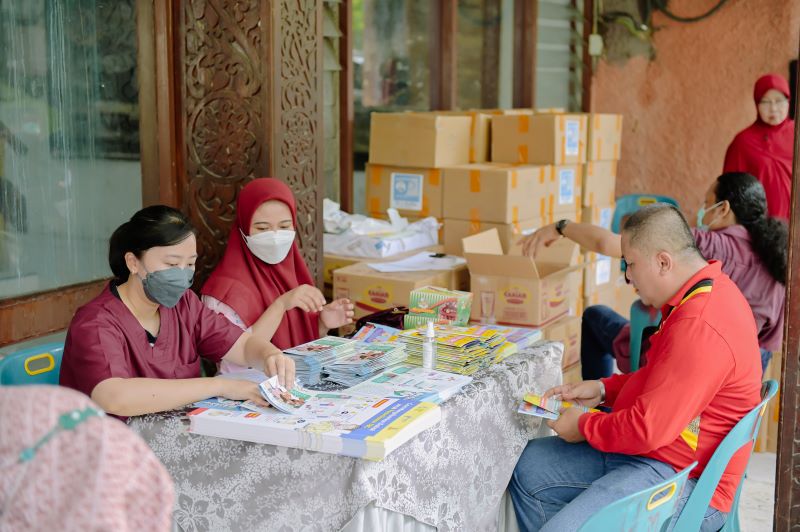 Health workers distribute educational materials to TB screening participants in Medan. Photo credit: USAID BEBAS-TB
