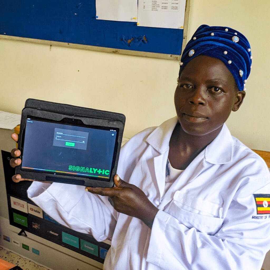 A health worker holds up a digital tablet used to improve health data reporting in Uganda. SSCS. Photo credit: MSH