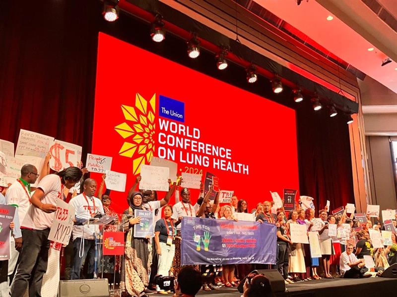 Activists at the World Conference of Lung Health in Bali, Indonesia demand a drop in the price of TB test GeneXpert. Photo credit: Health Policy Watch