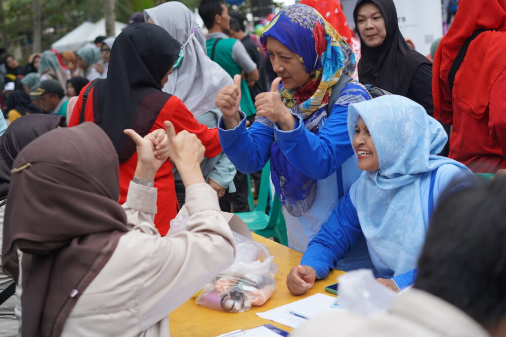 Health workers screen community members for TB, provide education on the disease, and give out hand sanitizer at the TB-Alert Village launch event. Photo credit: USAID BEBAS-TB