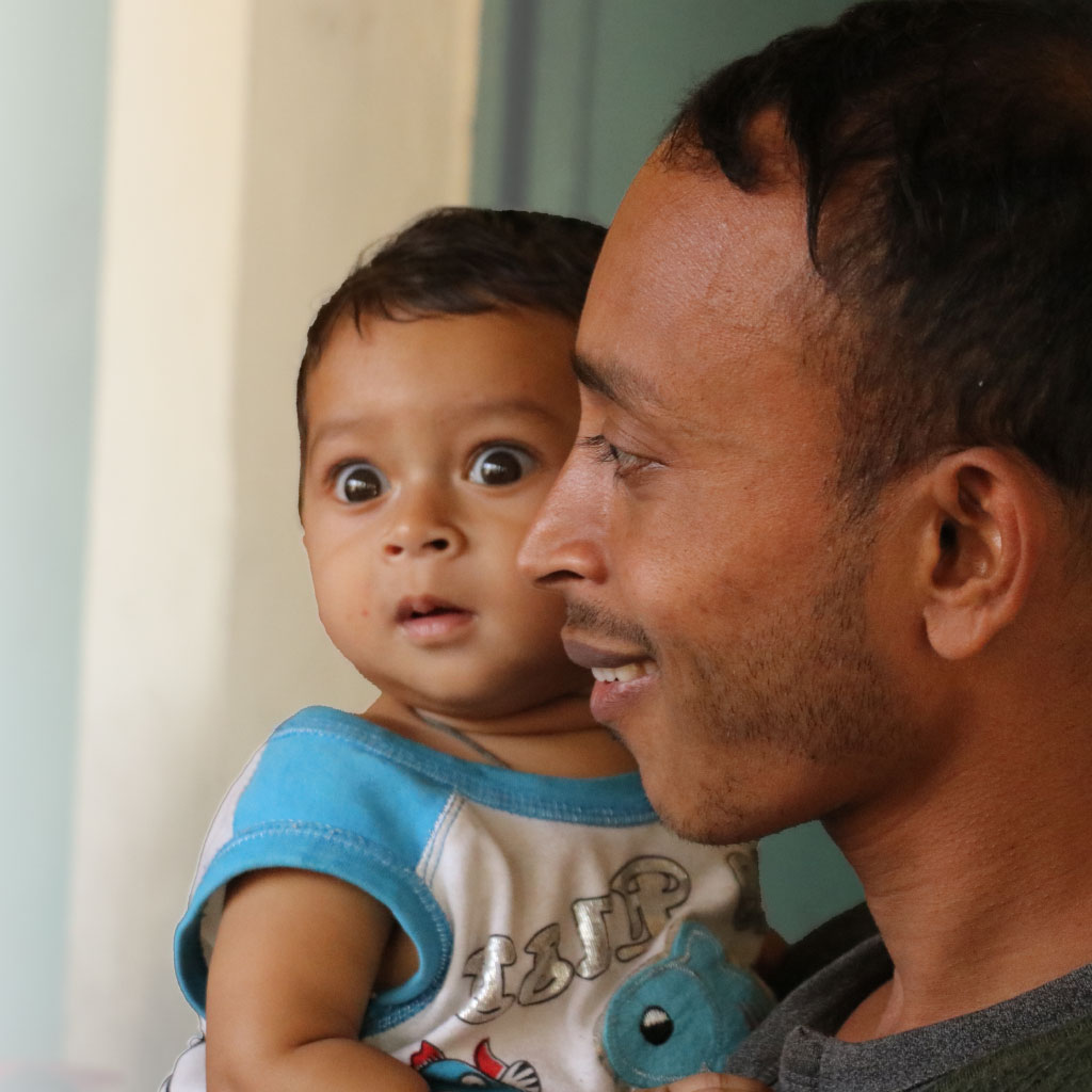 A father holds a child in Bangladesh.