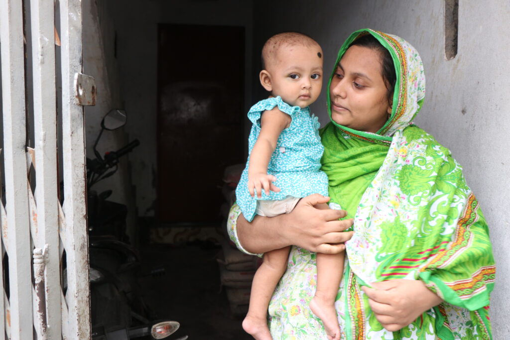 A woman holds a baby in her arms