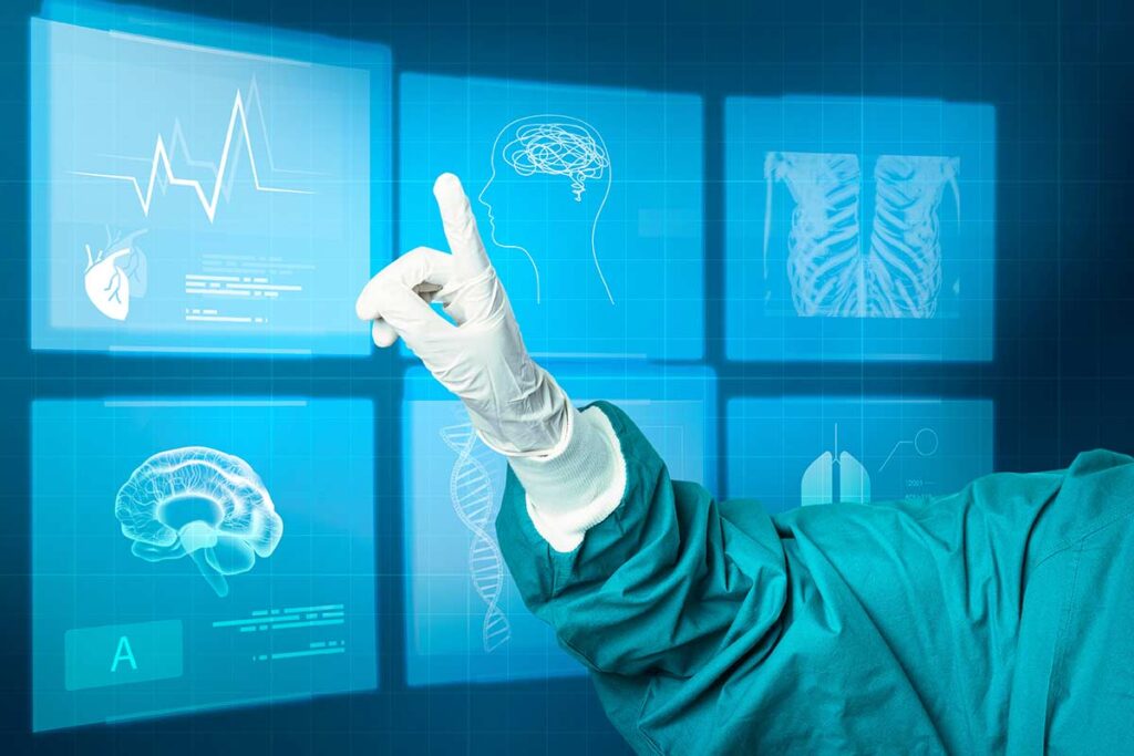 Hang pointing in front of various medical screens.