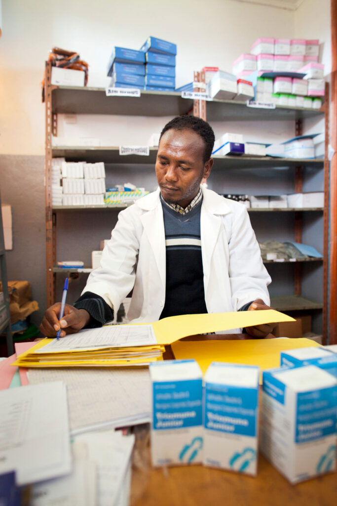 Um farmacêutico na Etiópia examinando seus livros.