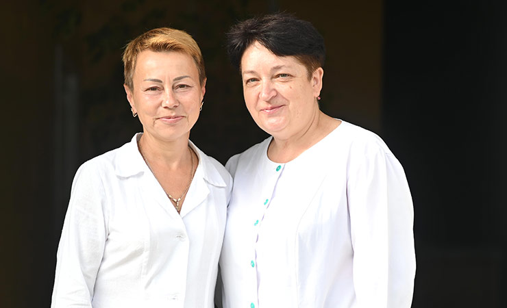 Two Ukrainian health worker in front of a clinic.