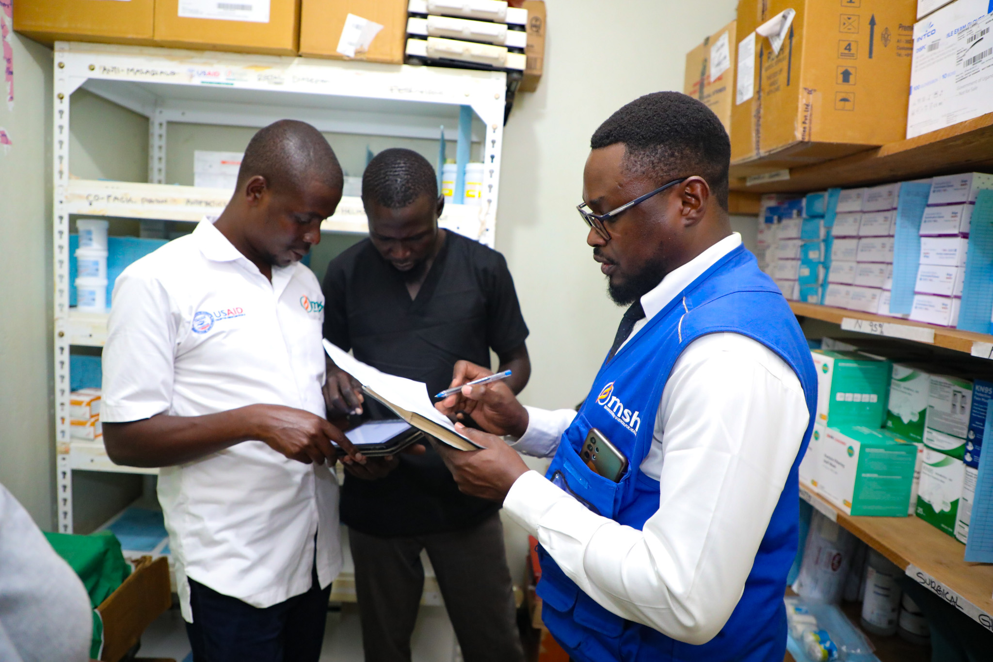 A group of people checking medicine inventory.