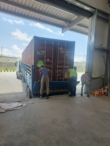 Two men locking a container in a warehouse.