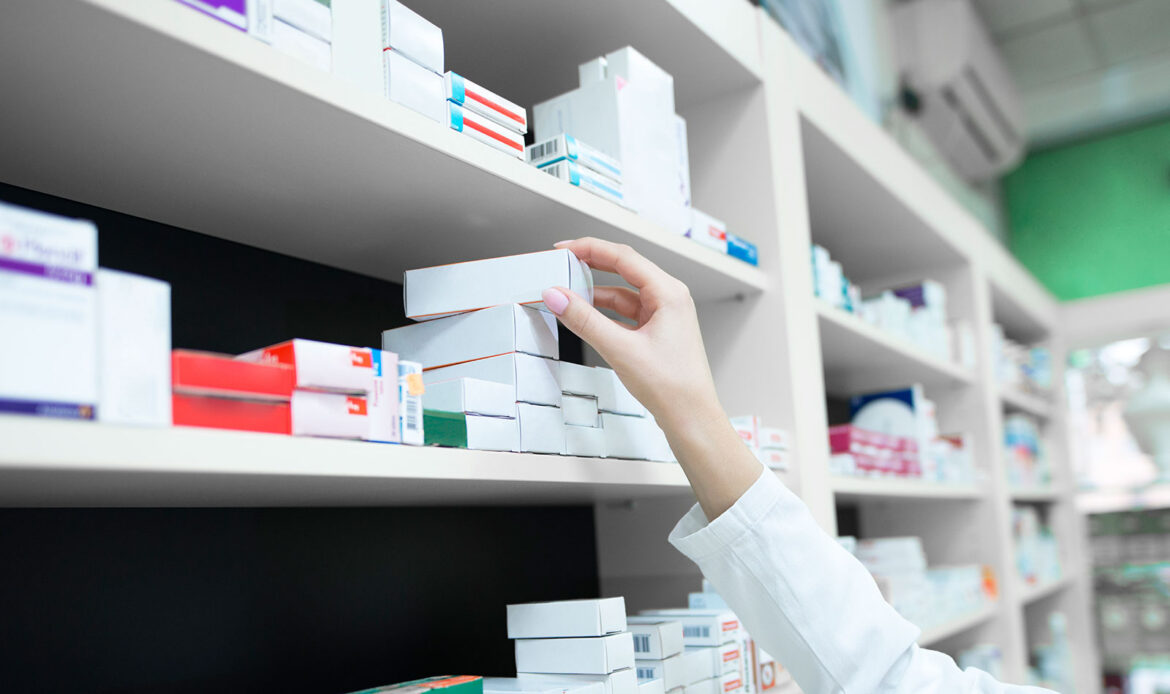 A pharmacist's hand reaching for a box od medicine