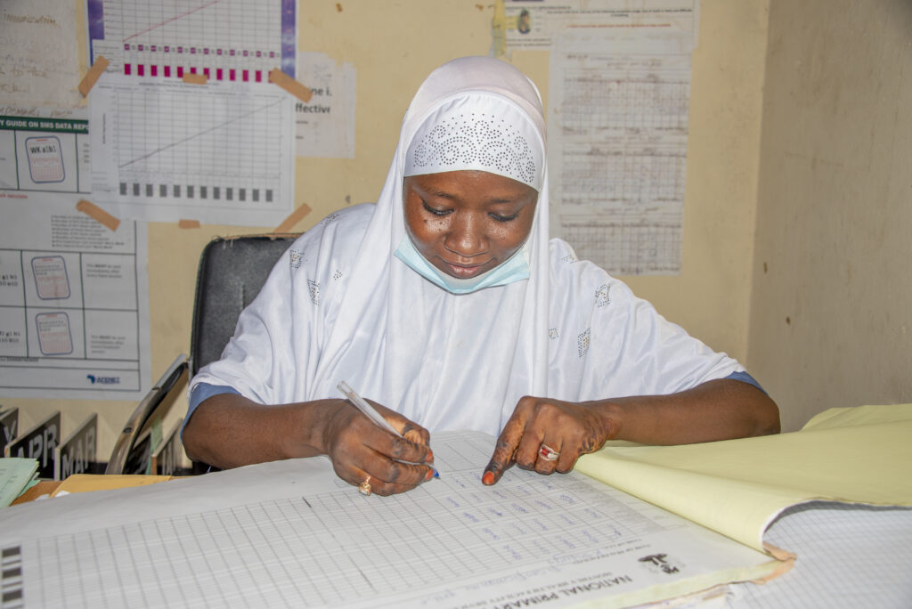 A community health worker in Nigeria filling out a report