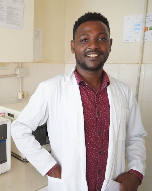 A smiling healthcare professional wearing a white coat