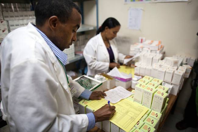 Healthcare professionals review medicine inventory records.