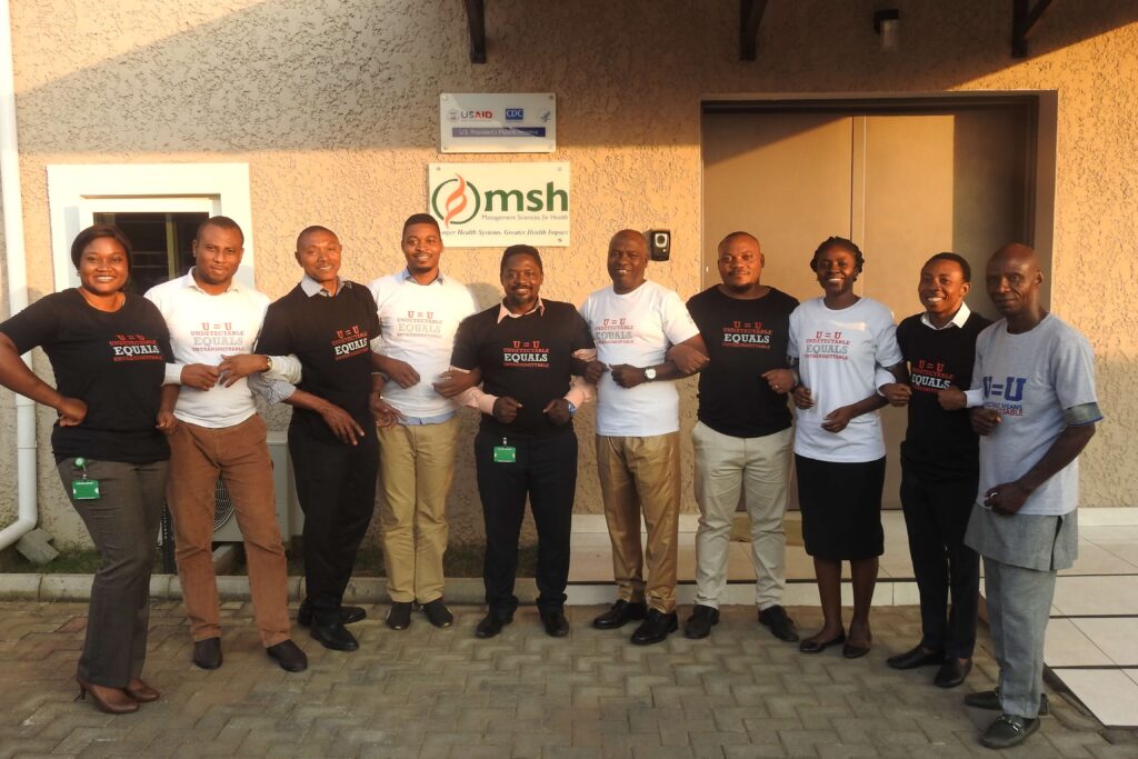 Smiling MSH Nigeria locking arms in front of the office.