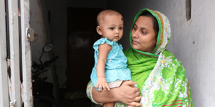 A mother in Bangladesh smiling at her beautiful baby girl.