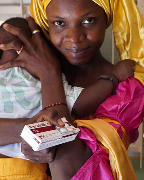 A mother holding a box of anti-biotics